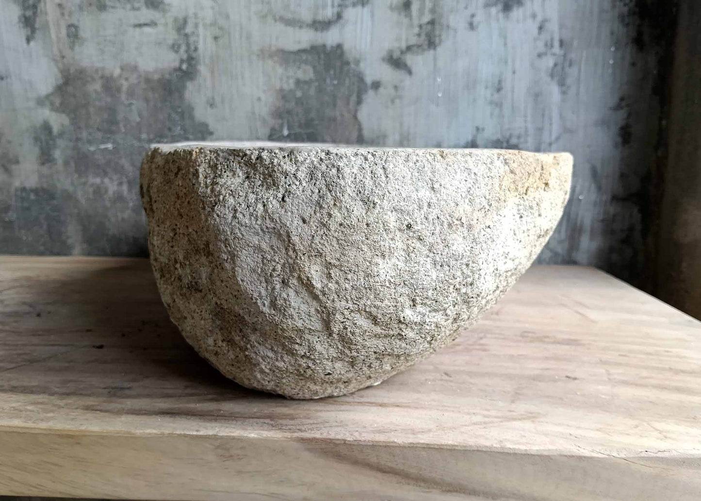 Right side view of oval beige river stone sink SKU 6026-5435 with rough textured exterior and smooth interior finish