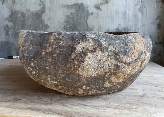 Front view of oval stone sink with rough exterior and polished inside