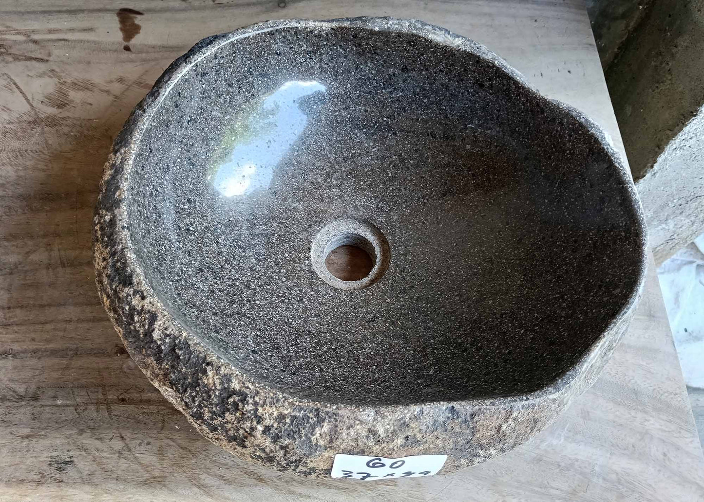 Top view of dark gray river stone sink with smooth oval interior