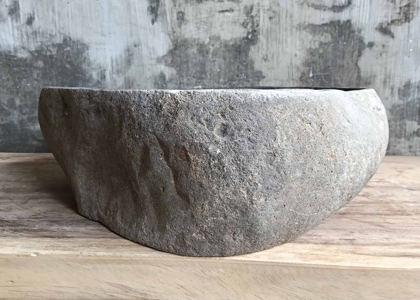 Right side view of handcrafted triangular dark gray river stone sink SKU 6077-5044 with rugged exterior and polished interior finish