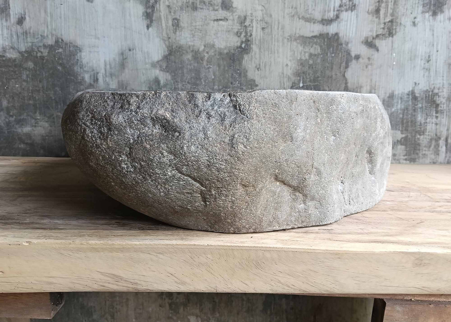 Left side view of triangular river stone sink SKU 6077-5044 with uneven natural stone exterior and polished interior surface