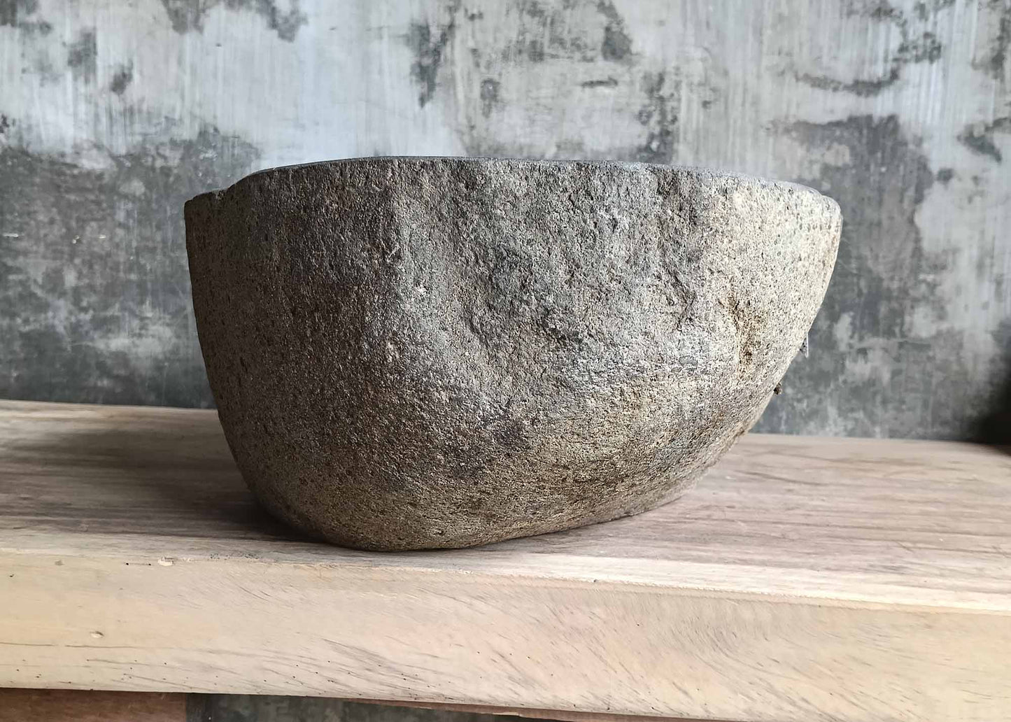 Left side view of oval river stone sink SKU 6116-5032 with natural uneven stone exterior and polished interior finish