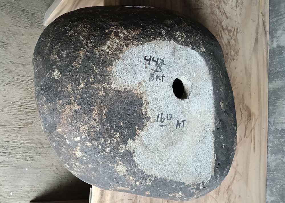 Bottom view of stone sink SKU 6160-5141 with rough natural base and product label visible