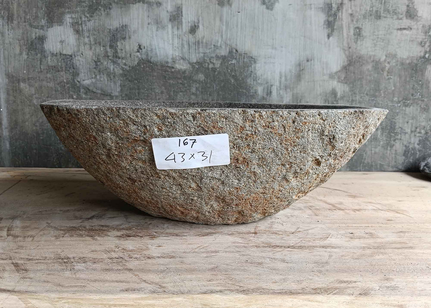 Back view of 17×12 inch oval gray river stone sink with natural stone surface