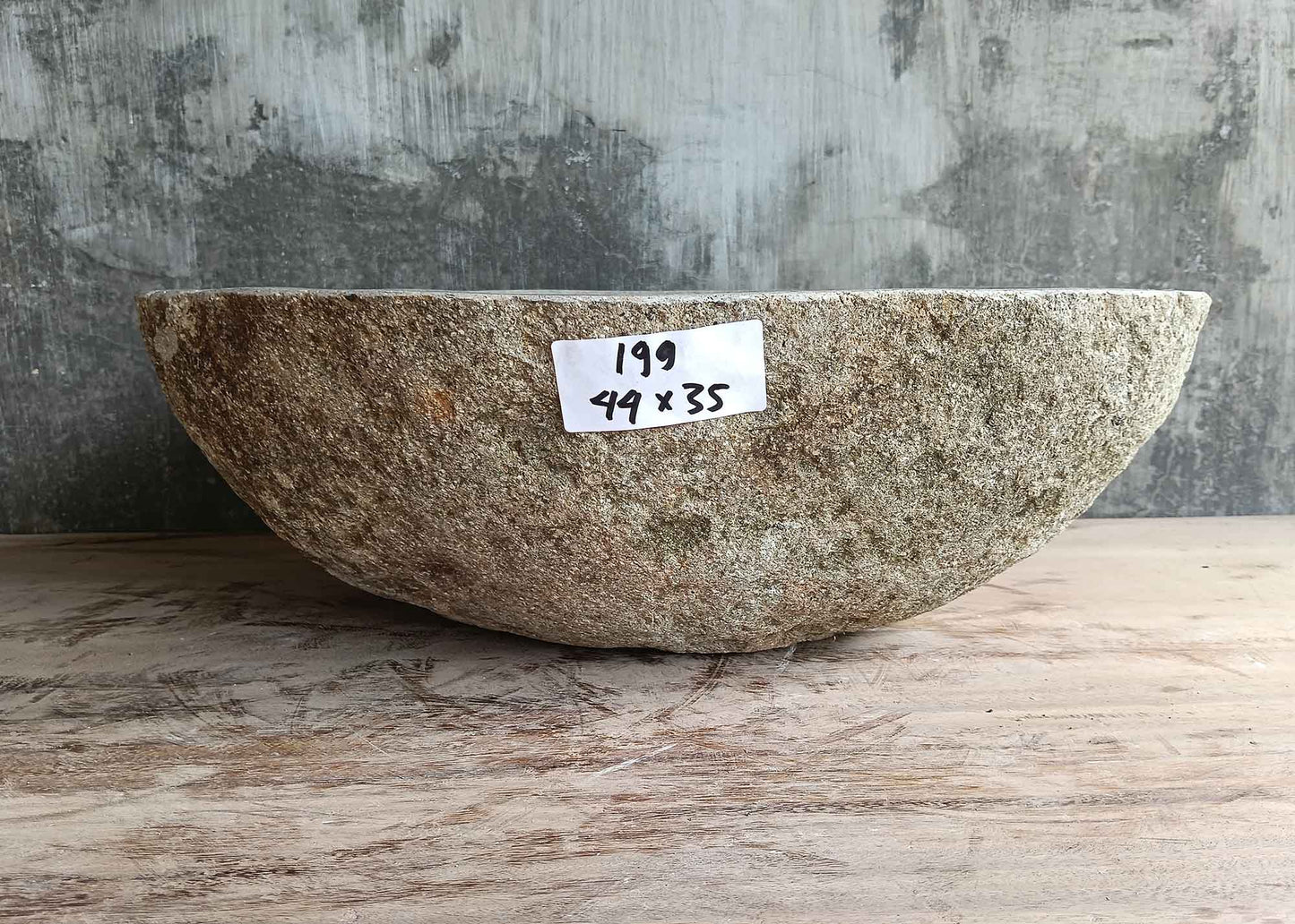 Back side of light 17×14 inch oval river stone sink with natural outer texture