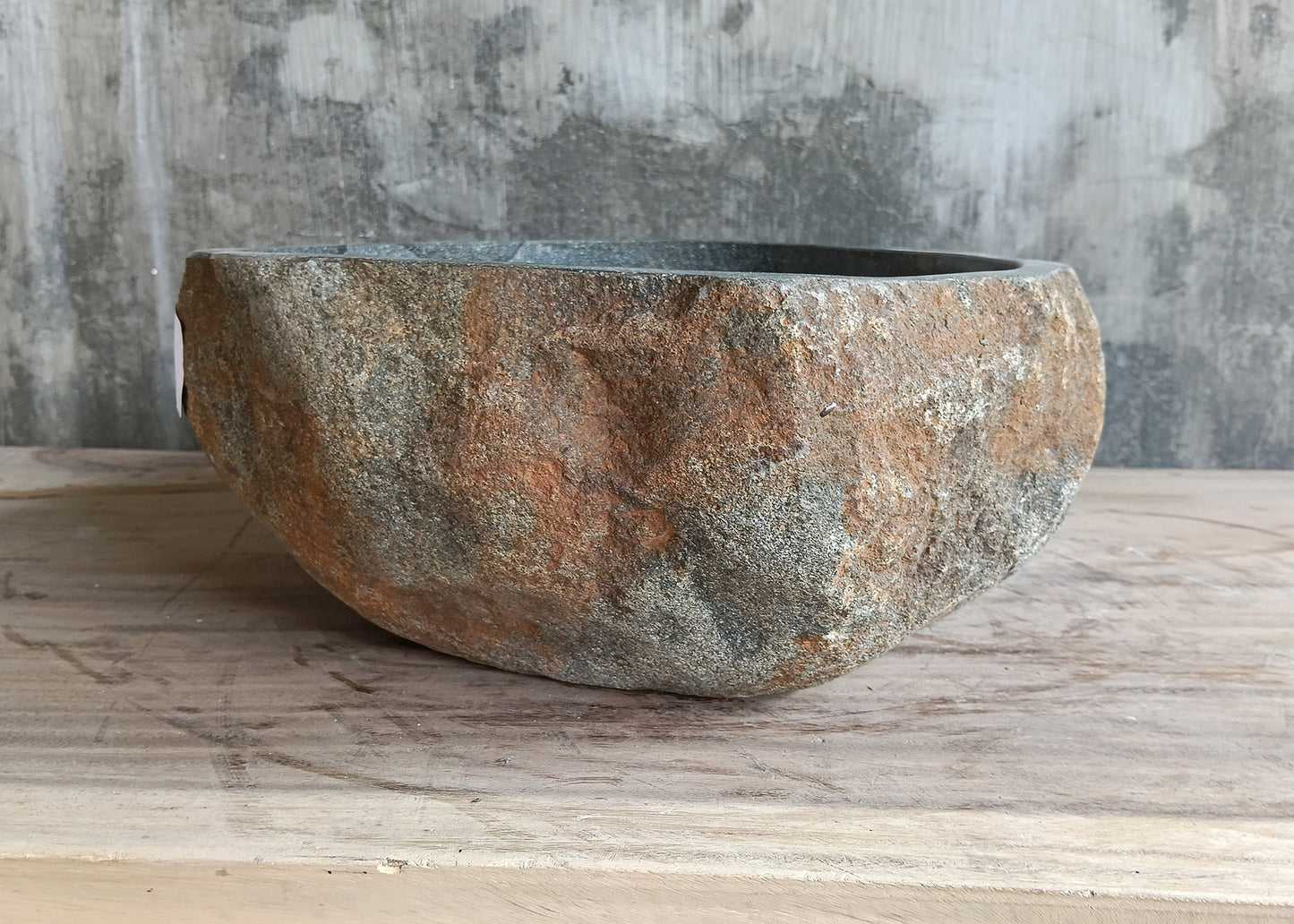 Close-up of triangular gray vessel sink highlighting natural veining and matte texture