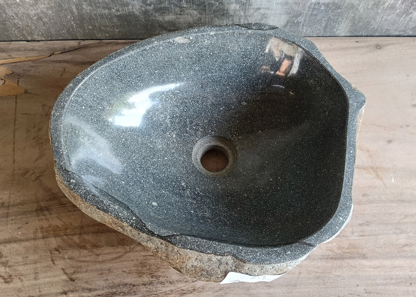 Top view of a handcrafted gray river stone sink with triangular shape and polished basin