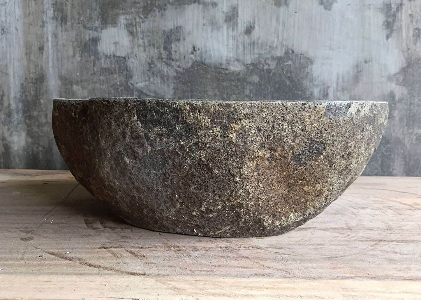 Back view of 16×12 river stone sink with raw exterior and deep gray tone