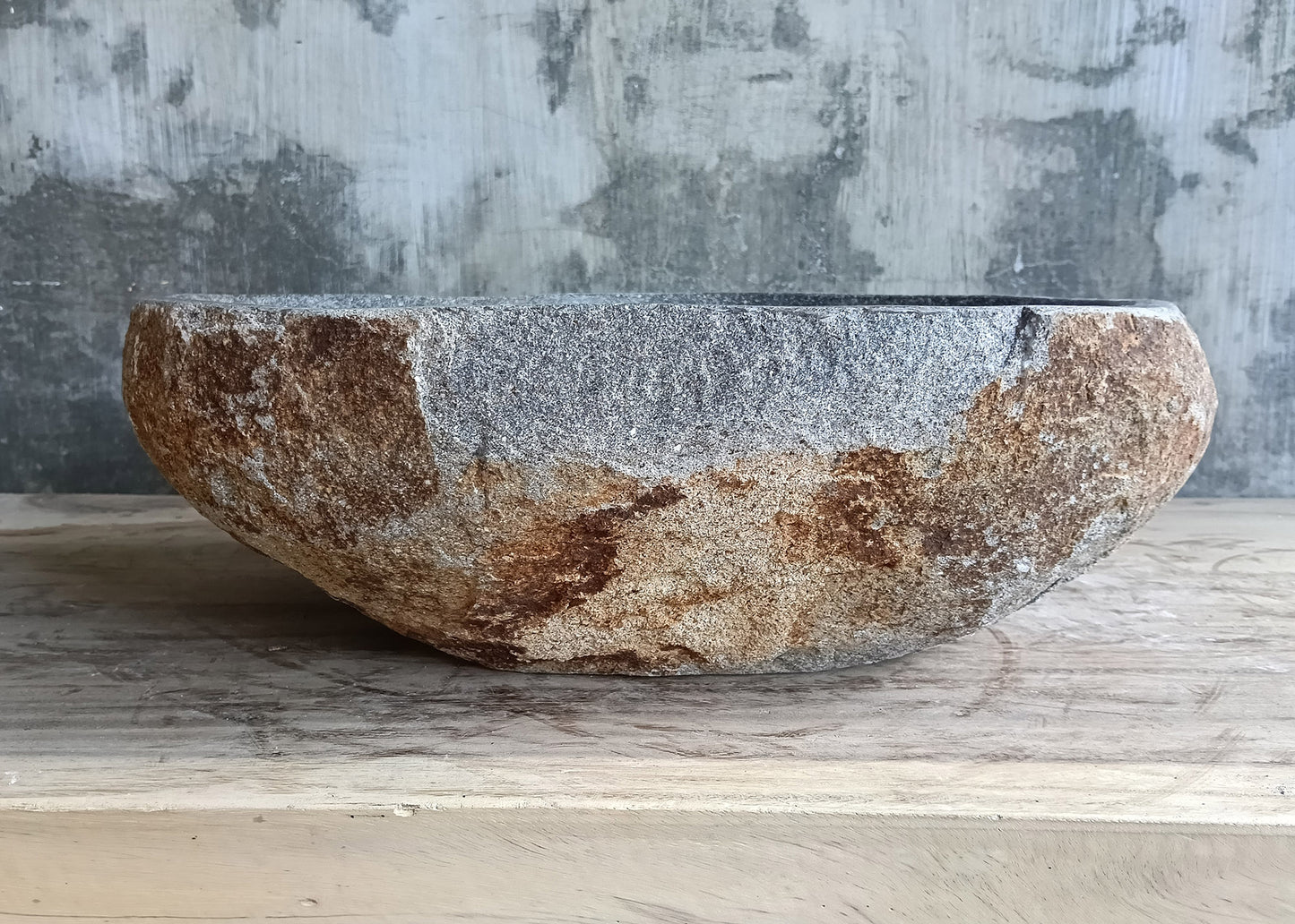 Back view of handcrafted river stone sink with textured raw finish