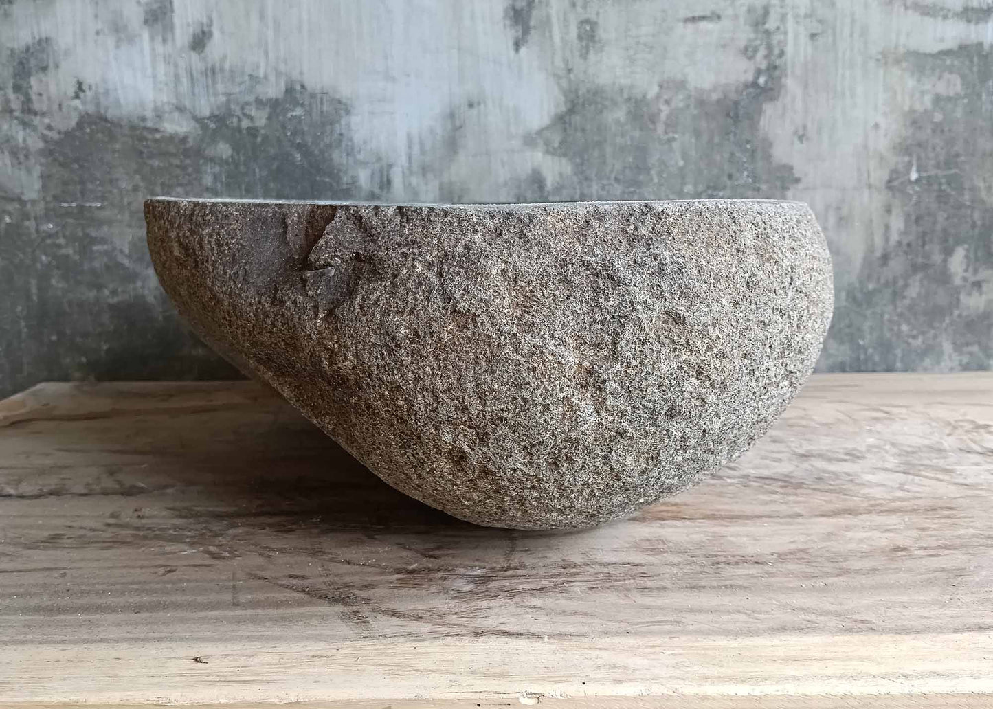 Left side of triangular stone sink showing natural texture