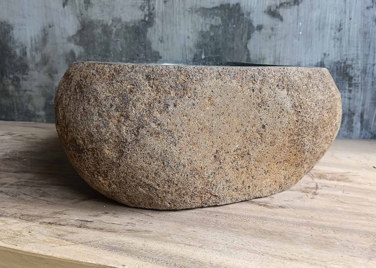 Left side of handcrafted sink with uneven natural stone lines