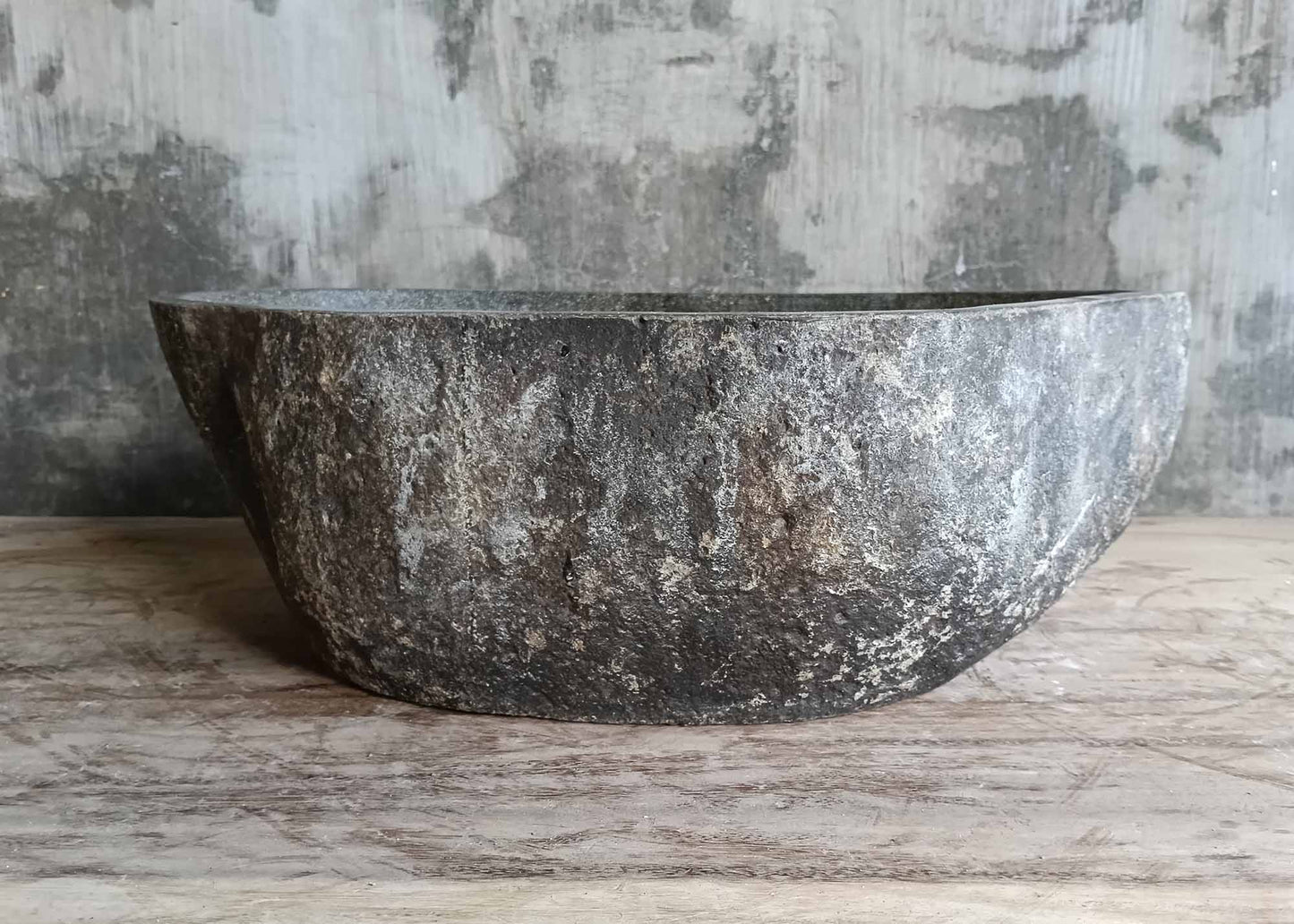 Rear side of elongated river stone basin in dark finish