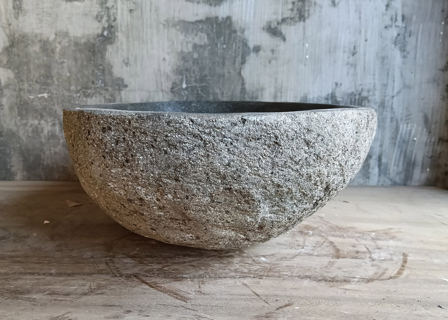 Left side view of rustic bathroom sink made from solid river rock with natural edges