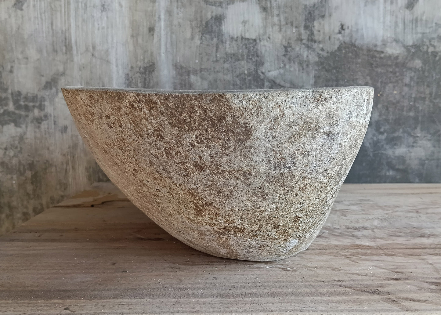 Right angle of handcrafted sink highlighting raw texture and asymmetrical curvature