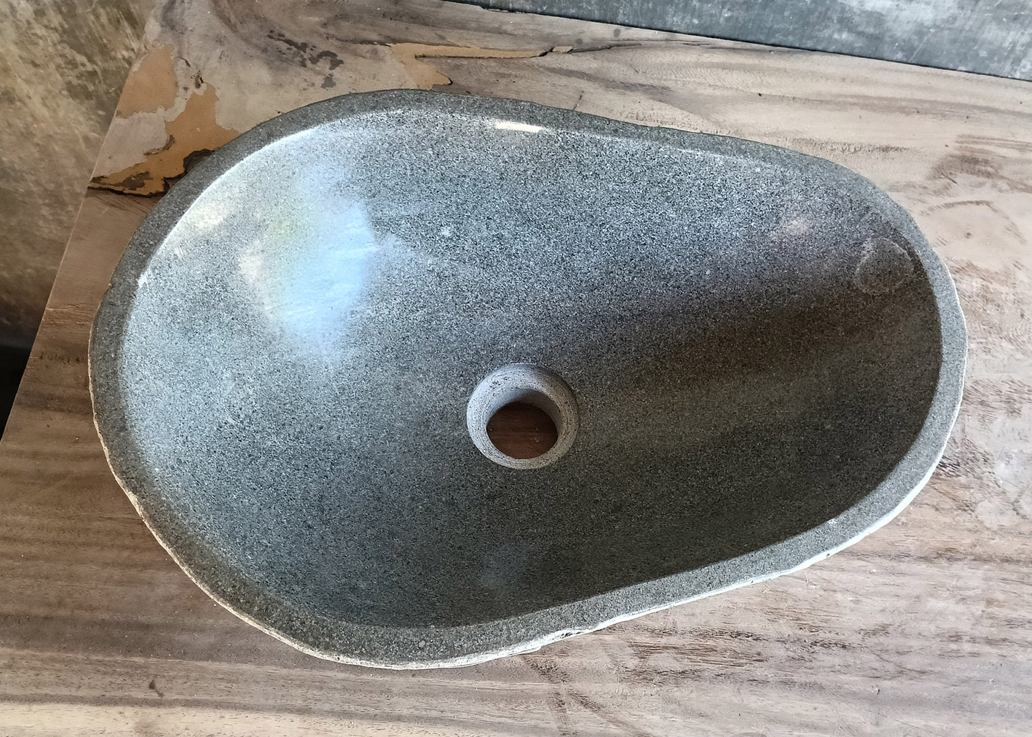Top view of handcrafted avocado-shaped stone sink with smooth light gray interior
