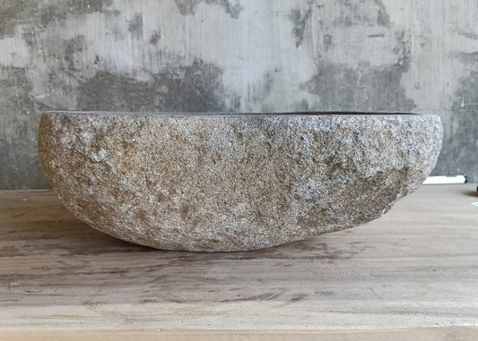 Front view of handcrafted stone basin with boat-like profile and rugged texture