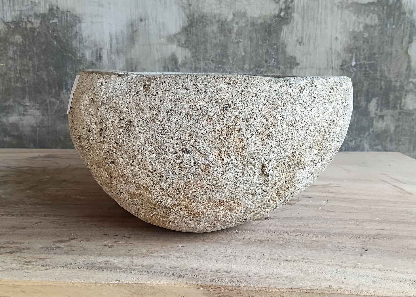 Left side view of 13×11 inch light river stone sink with smooth round form