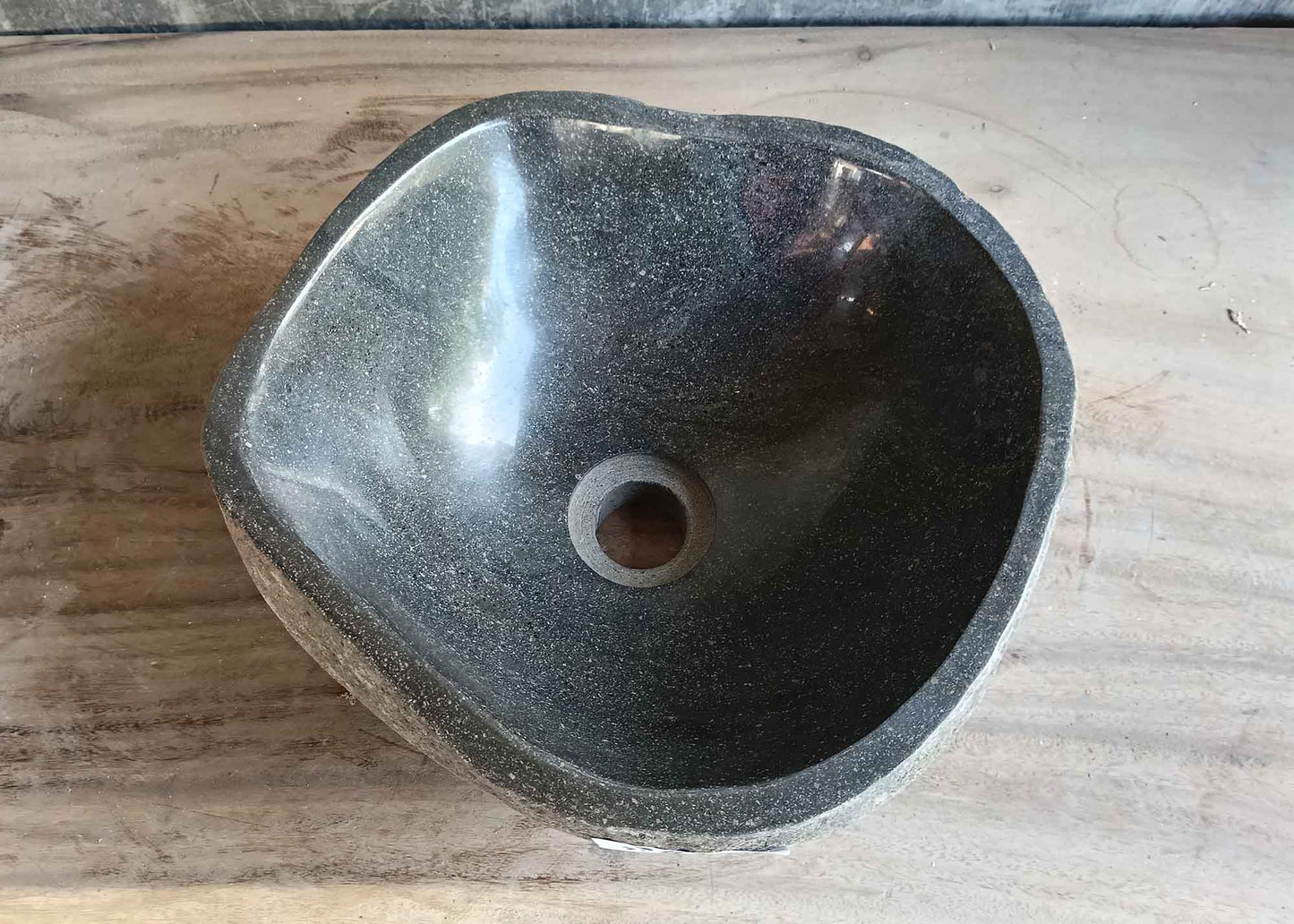 Top view of handcrafted 12×12 inch dark gray river stone sink with smooth round interior