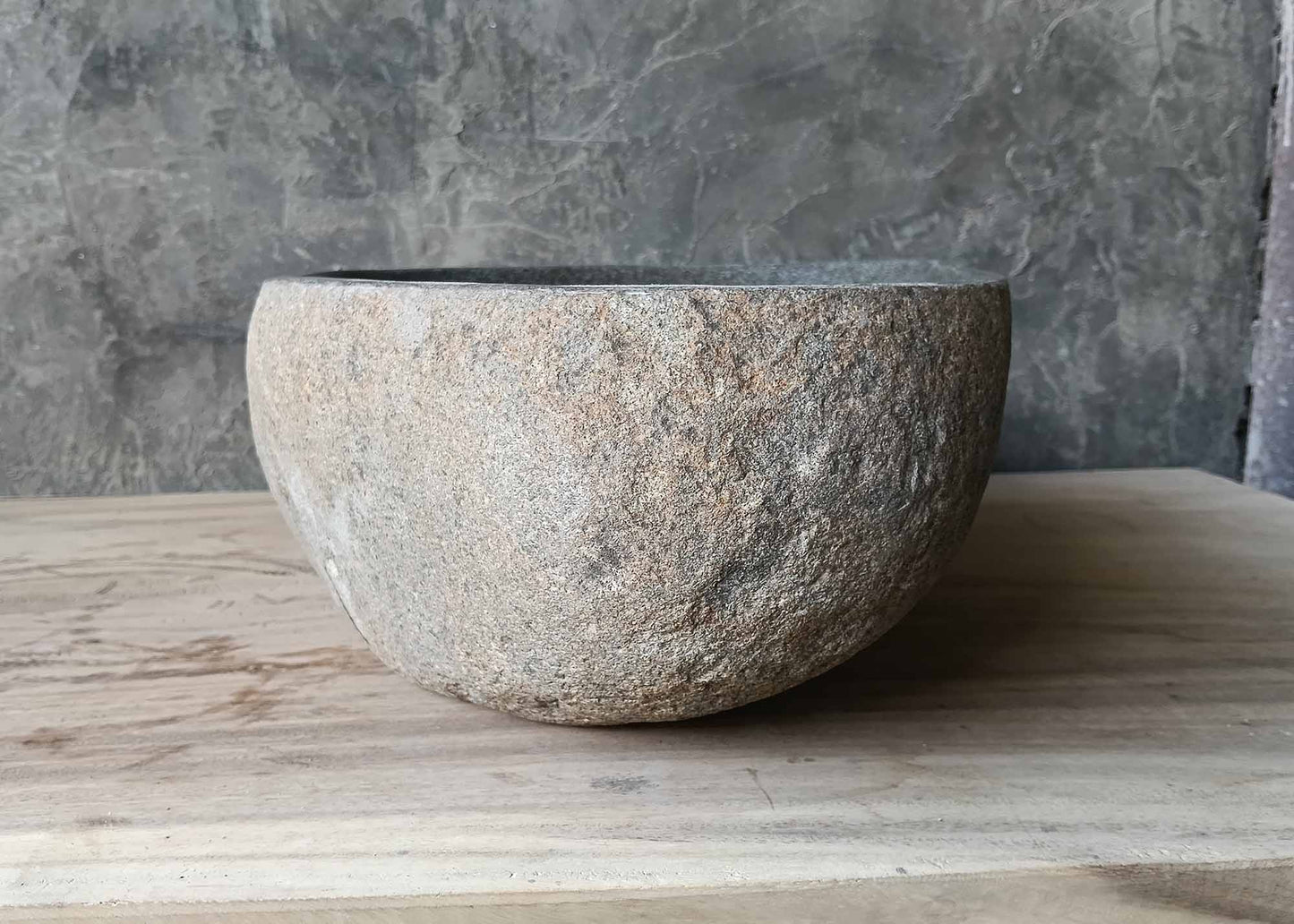 Angled side view highlighting the organic curves and raw stone finish