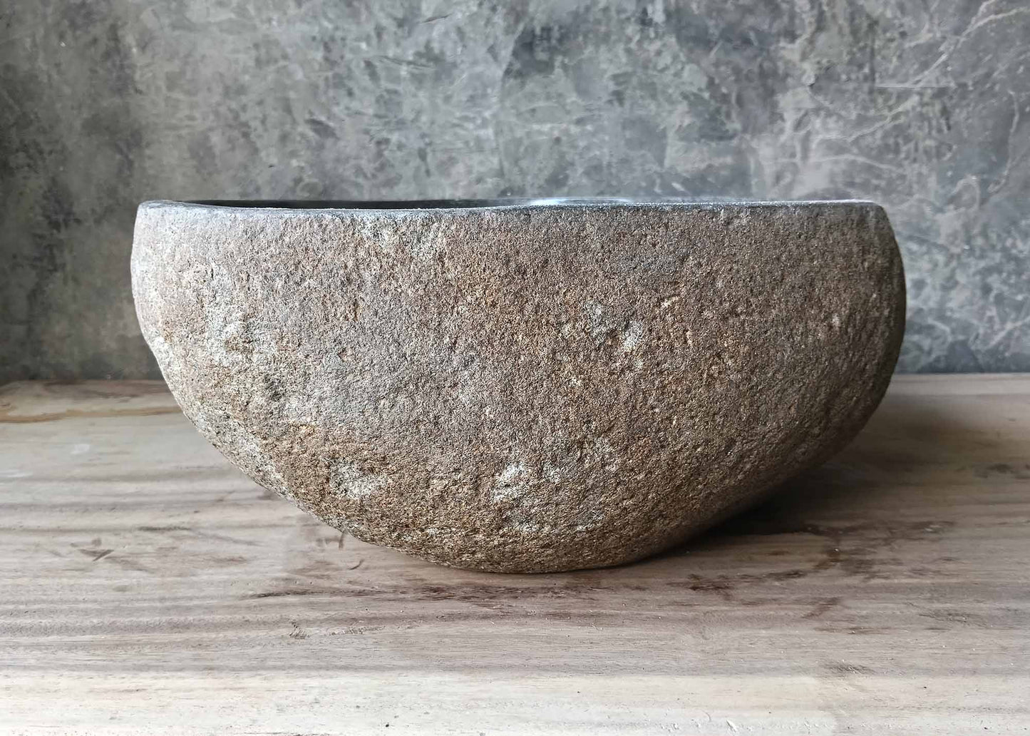 Side angle showing rustic stone texture and smooth upper edge of the sink