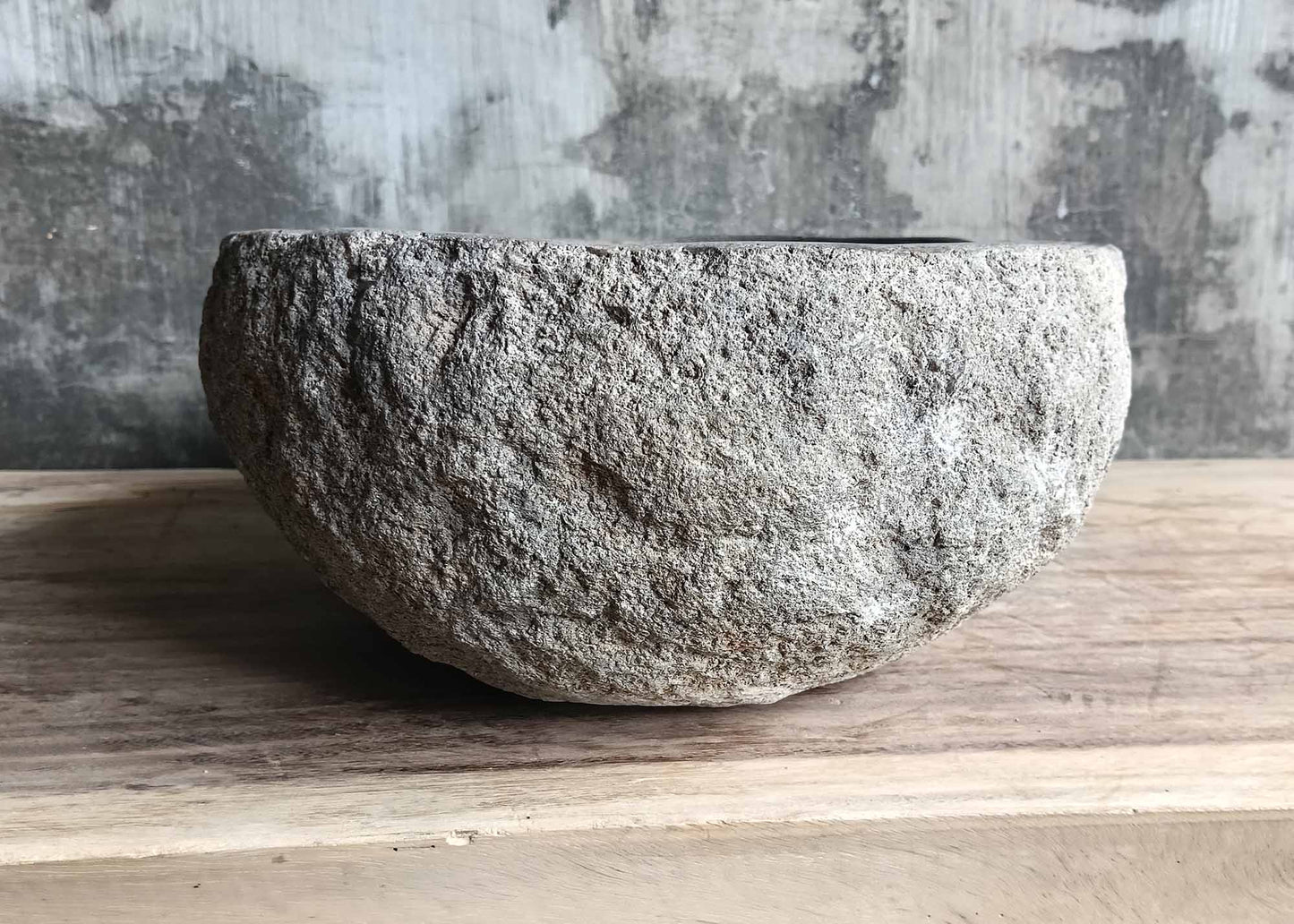 Right side angle of oval stone sink with rough texture and soft curves