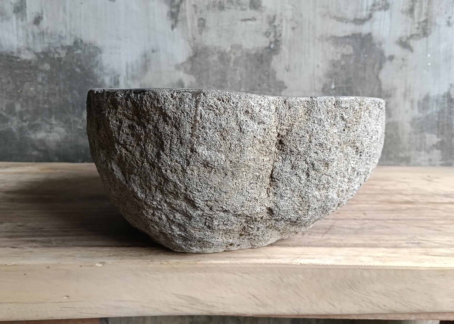 Left side of river stone sink featuring thick wall and uncut stone finish