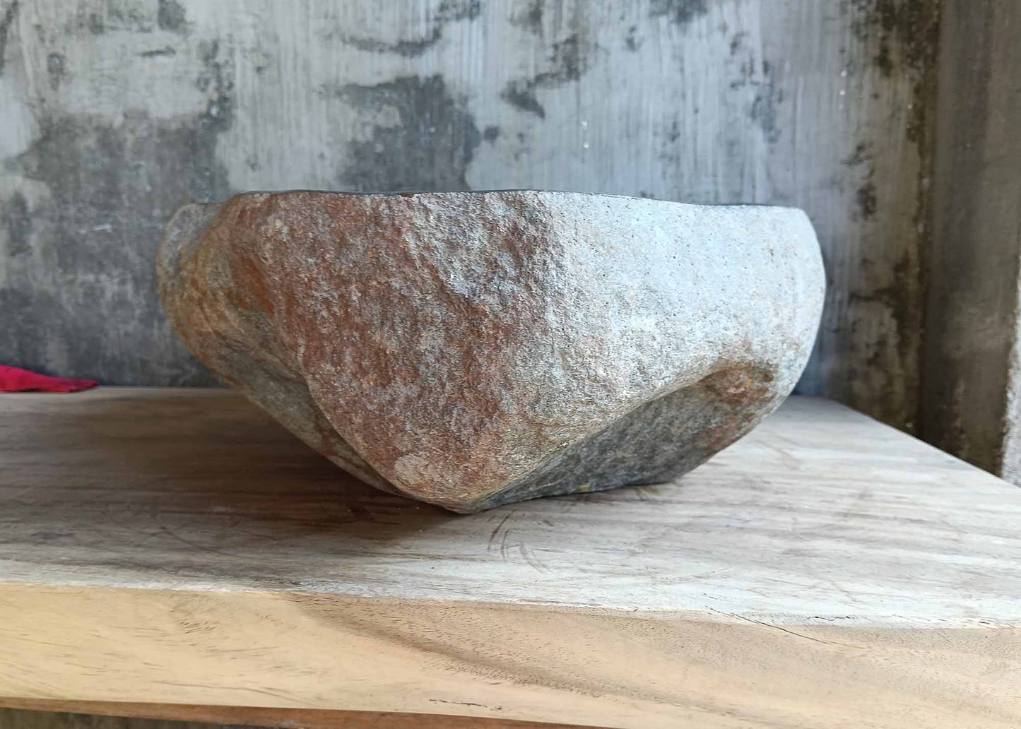 Left-side profile of river stone sink with volcanic-style surface and solid base
