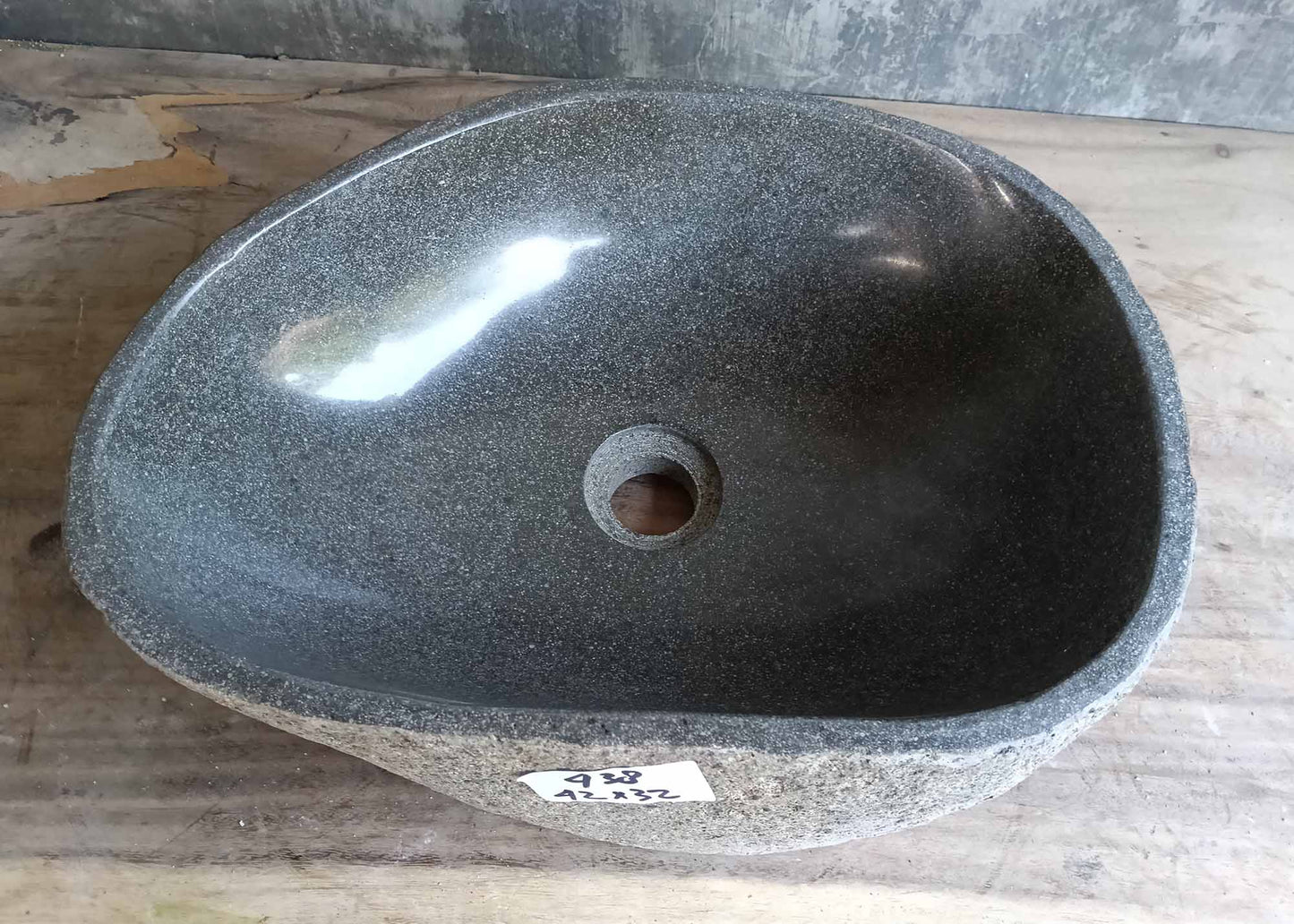 Top view of a handcrafted river stone sink with soft gray interior and oval shape