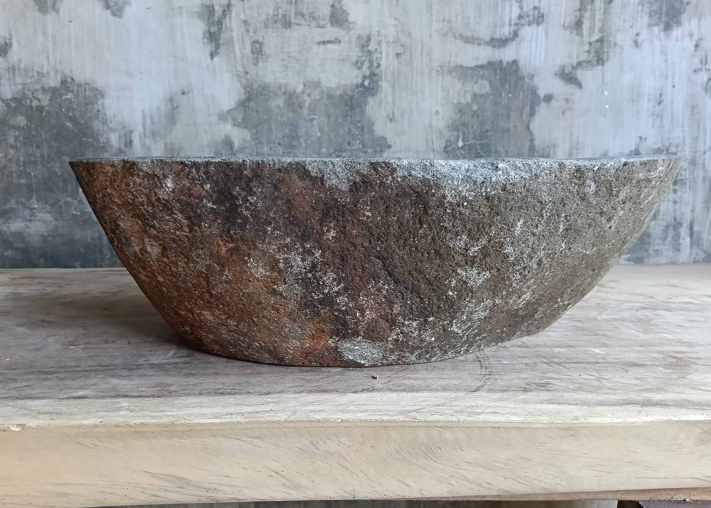 Backside of boat-style river sink showing natural textured stone