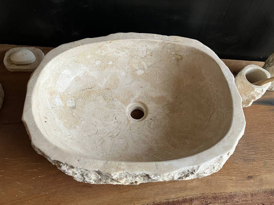 Natural beige marble bathroom sink BMS-009 showing its rough chiseled stone exterior