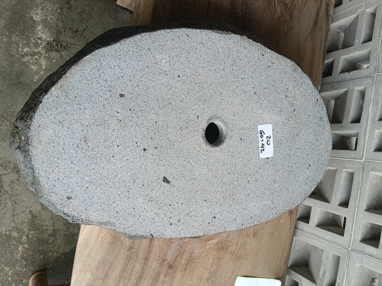 Bottom view of oval andesite stone sink with drain hole