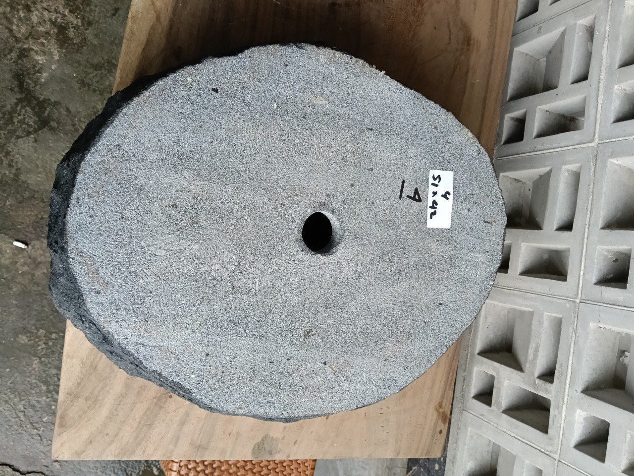 Bottom view of oval andesite stone sink with drain hole