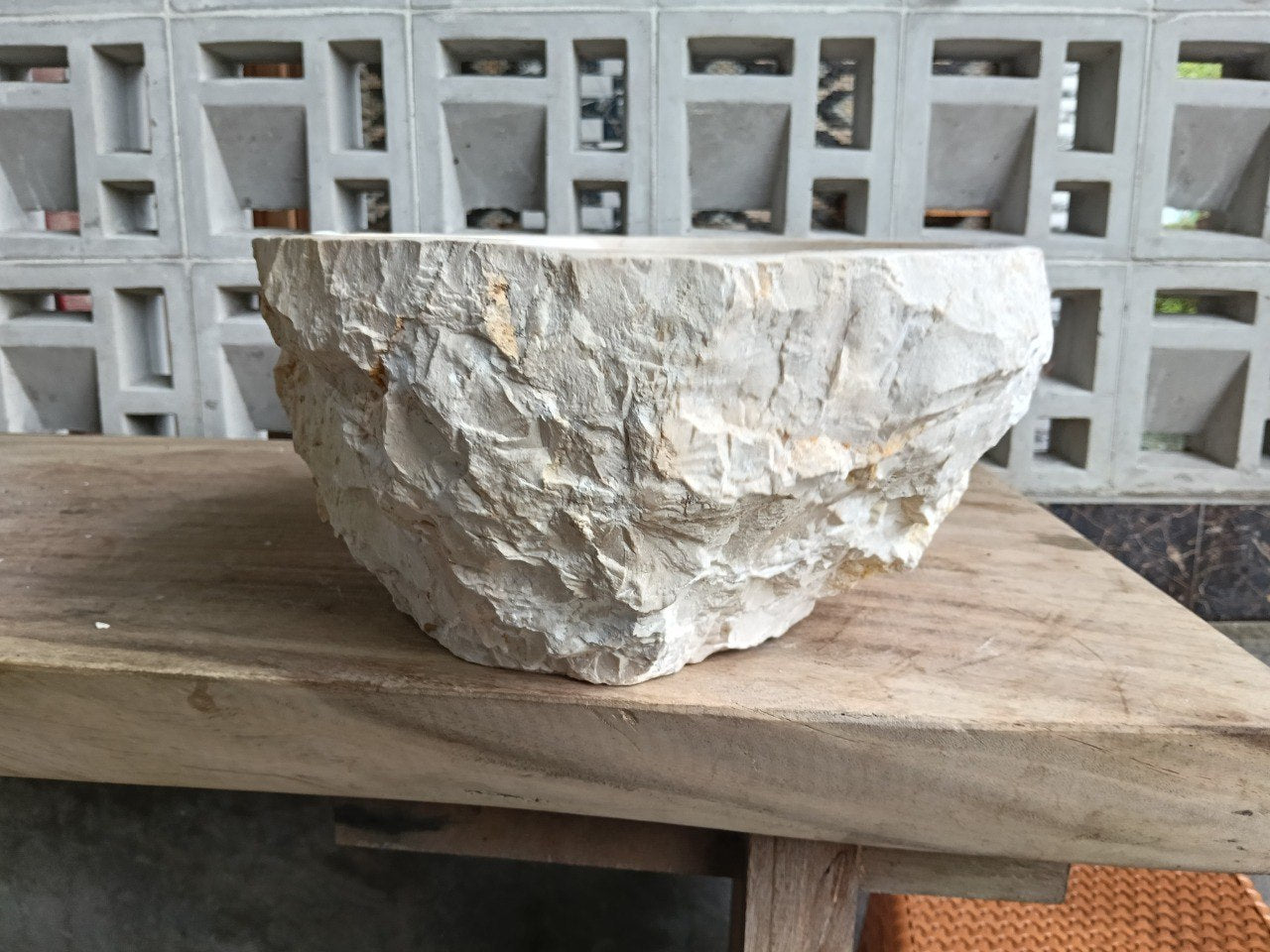 Bottom view of oval beige marble sink with drain hole