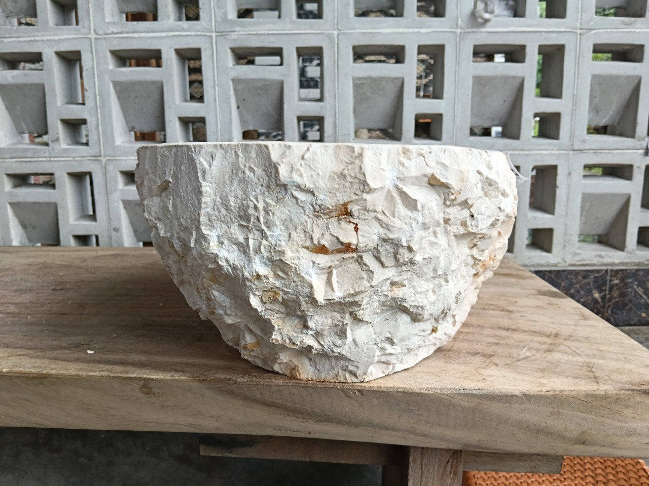 Right side perspective of handcrafted oval beige marble stone sink