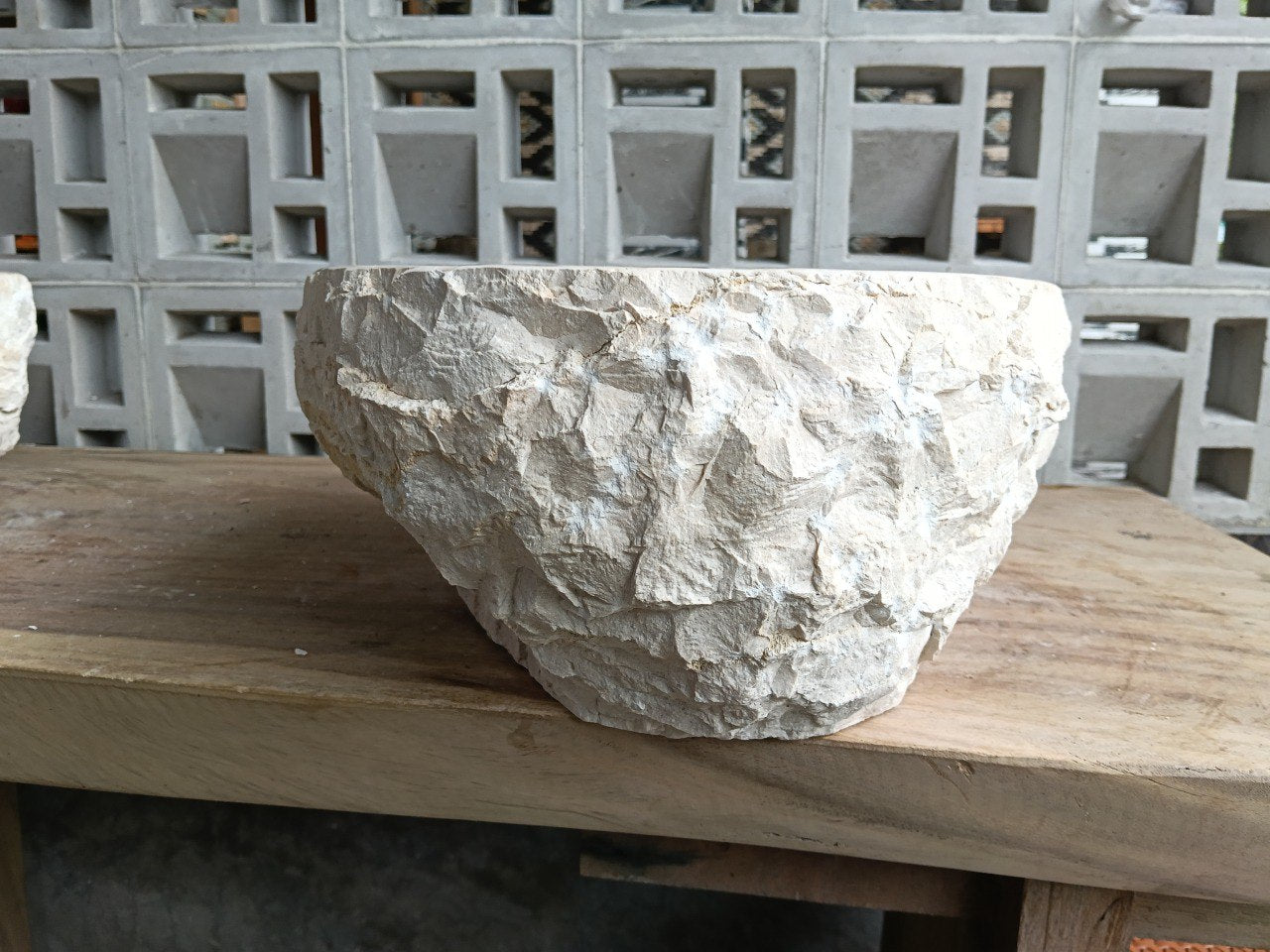 Back view showing natural split-rock exterior of beige marble sink