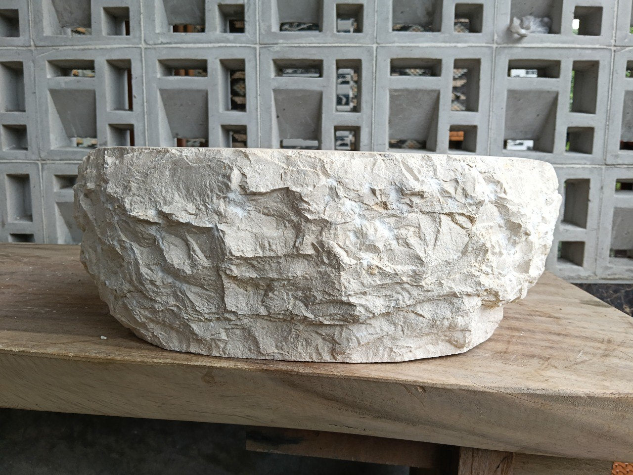 Right side perspective of handcrafted beige marble stone sink