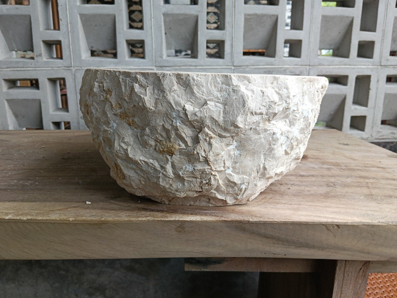 Right side perspective of handcrafted beige marble stone sink