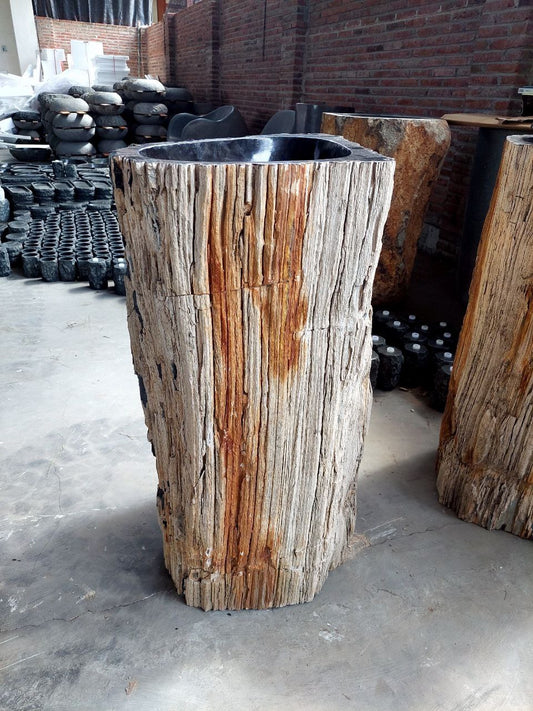 Side angle of petrified wood pedestal sink showing fossilized bark exterior