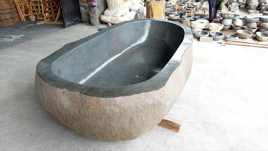 Side angle of natural river stone bathtub showing rugged exterior