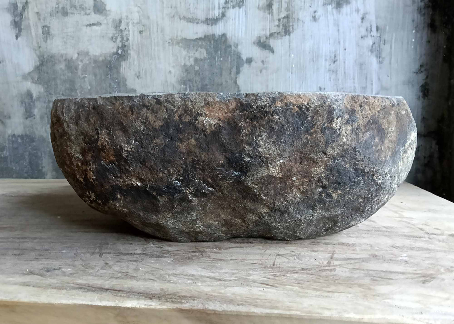 Rear view of oval river stone sink with organic uneven edges and polished interior surface