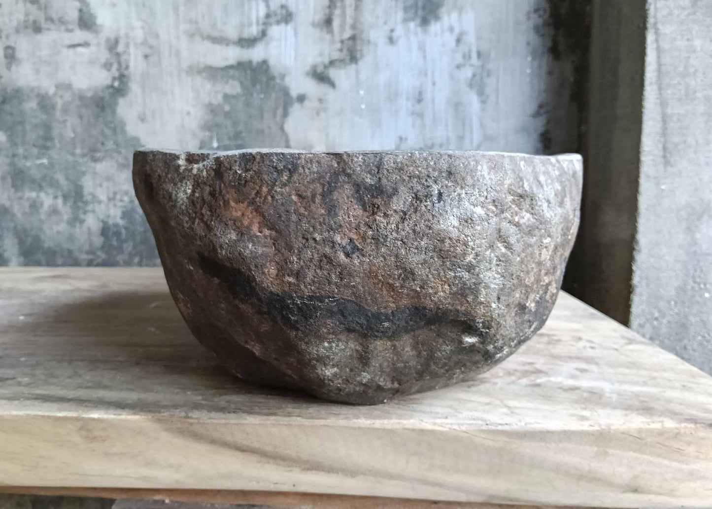 Left side view highlighting natural stone texture and oval shape of handcrafted river stone sink