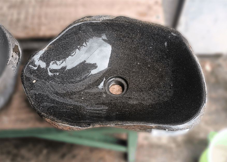 Top view of handcrafted 17×13 inch river stone sink with grey interior and brown-rust exterior