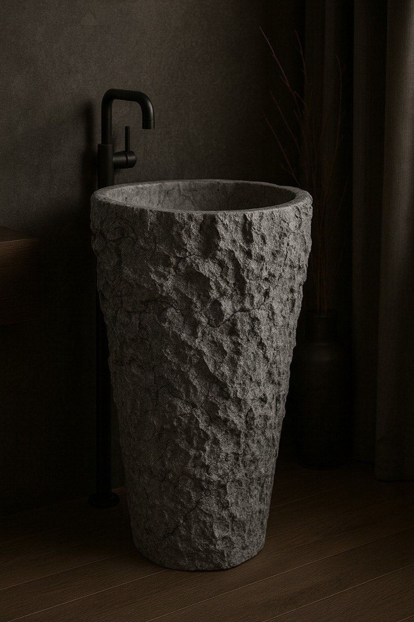 Grey marble pedestal sink with rough textured exterior and polished basin in dark modern bathroom