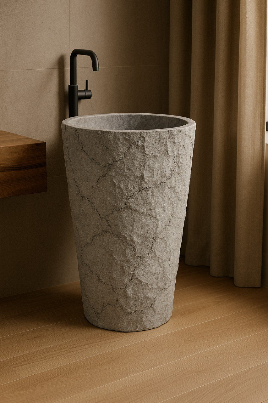 Beige marble pedestal sink with rough textured surface and polished basin in luxury bathroom