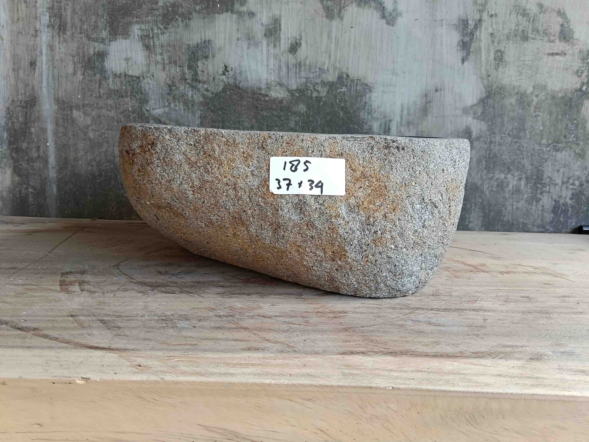 Side view of 15×13 inch light-gray river stone sink installed in countertop
