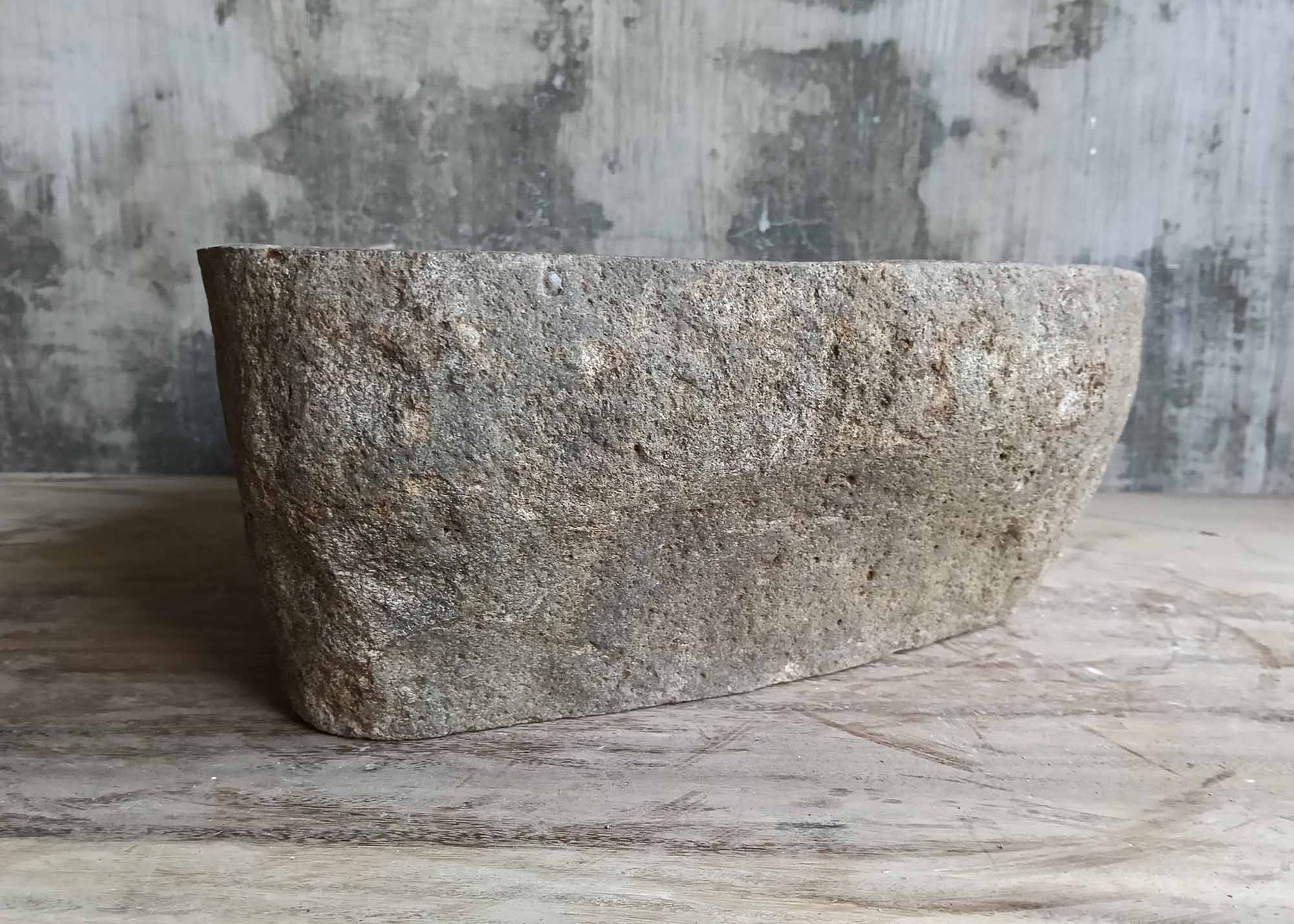 Left side angle of speckled gray river stone basin with natural edges
