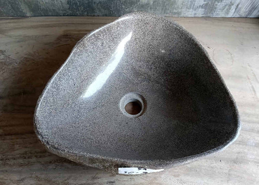 Polished gray interior of triangular river stone sink viewed from above
