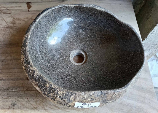 Top view of dark gray river stone sink with smooth oval interior
