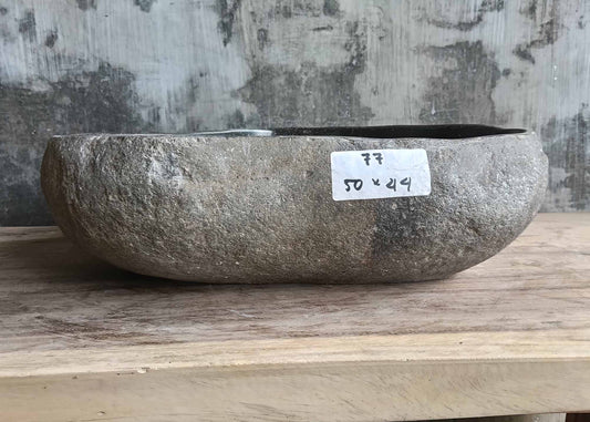 Front view showing natural textured dark gray stone exterior of river stone sink SKU 6077-5044 with organic triangular shape
