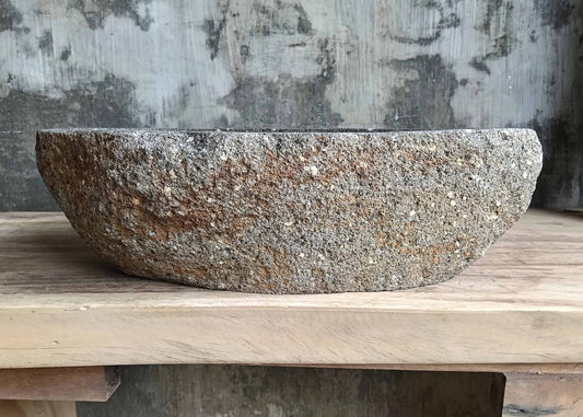 Front view showing natural rugged dark gray stone exterior of river stone sink SKU 6083-5335 with organic oval shape
